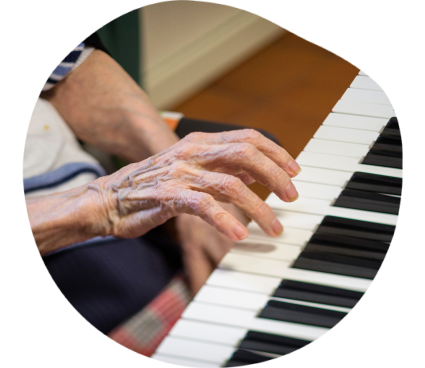 Une personne âgée joue du piano de sa main droite.